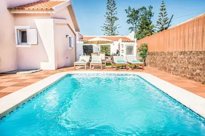 a swimming pool in the backyard of a house at Casa Alfazema in Albufeira
