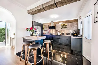 a kitchen with two bar stools and a counter at Casa Alfazema in Albufeira