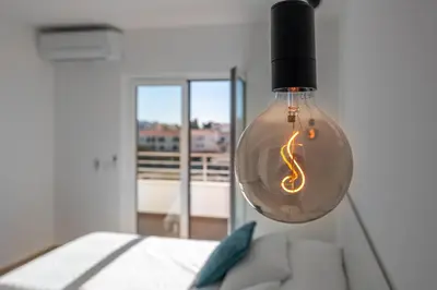 a light bulb hanging from a ceiling in a bedroom at Apart OCEAN DRIVE - Oura - Jacuzzi - BY BEDZY in Albufeira