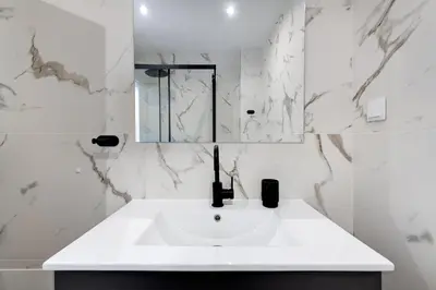 a white bathroom with a sink and a mirror at Apart OCEAN DRIVE - Oura - Jacuzzi - BY BEDZY in Albufeira