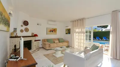 a living room with a couch and a fireplace at Villa Den, private pool villa, Sleeps 6 adults and 2 children, CD 304 - Cleverdetails in Vilamoura