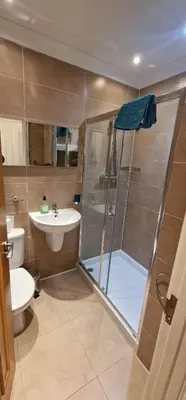a bathroom with a shower and a toilet and a sink at Villa Cristina in Quarteira