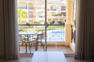 a balcony with a table and chairs and a view of a building at Praia Village I - Peaceful condominium by HD in Vilamoura
