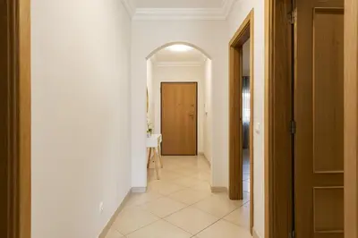 a hallway with white walls and an archway at Praia Village I - Peaceful condominium by HD in Vilamoura