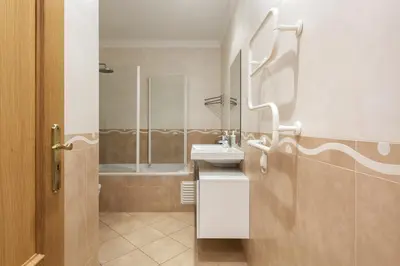 a bathroom with a sink and a mirror and a tub at Praia Village I - Peaceful condominium by HD in Vilamoura