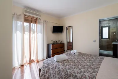 a bedroom with a bed and a television and windows at Villa Lucio by SAPvillas in Vilamoura