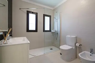a bathroom with a shower and a toilet and a sink at Villa Lucio by SAPvillas in Vilamoura