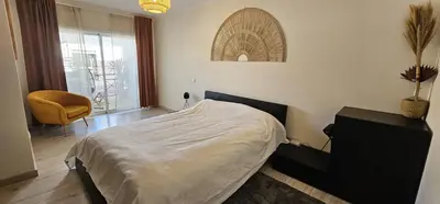 a bedroom with a bed and a chair and a window at Green Balcony Holiday Work Remote Big Apartment in Albufeira