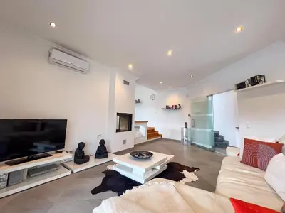 a living room with a couch and a tv at Beautiful 4-Bedroom Villa with Garden and Pool in Albufeira