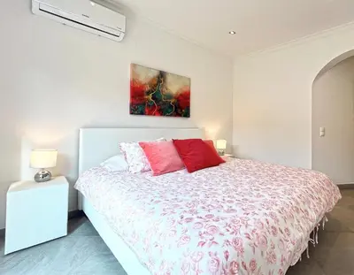 a bedroom with a bed and a painting on the wall at Beautiful 4-Bedroom Villa with Garden and Pool in Albufeira