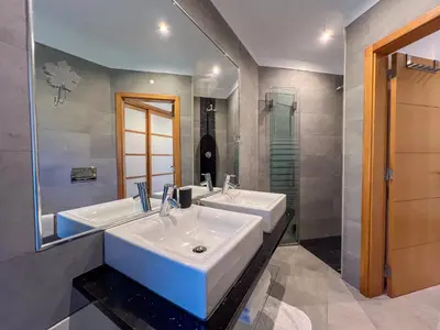 a bathroom with two sinks and a mirror at Beautiful 4-Bedroom Villa with Garden and Pool in Albufeira