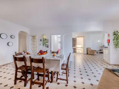 a dining room and living room with a table and chairs at Apartment T3 capricórnio - VIP Properties by Interhome in Galé