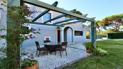 a kitchen and dining room with a table and stools at Villa Linda Rosa, CD 302 by Cleverdetails private pool, prime location in Vilamoura