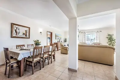 a dining room and living room with a table and chairs at Villa Agapito in Terras Novas