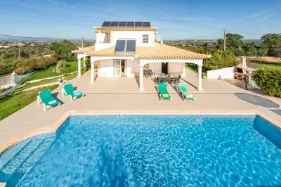 a villa with a swimming pool in front of a house at Villa Agapito in Terras Novas