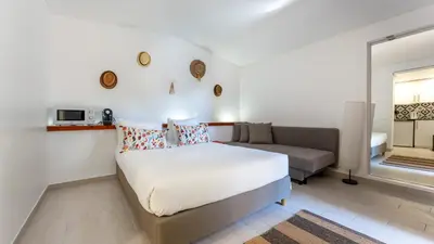 a white bedroom with a bed and a couch at Açoteias Studio w Pool by LovelyStay in Albufeira