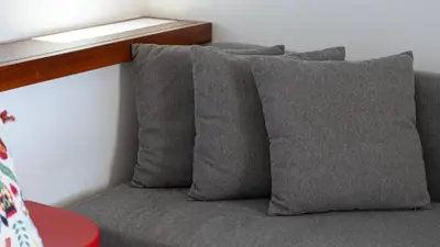 a group of pillows on a couch under a window at Açoteias Studio w Pool by LovelyStay in Albufeira