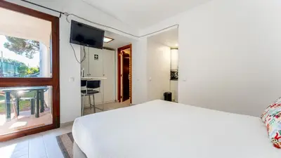 a bedroom with a white bed and a window at Açoteias Studio w Pool by LovelyStay in Albufeira