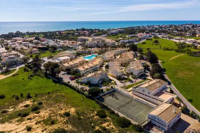 a building with a palm tree next to a driveway at Ponta Grande Resort - Villa Dourada in Albufeira
