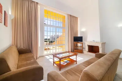 a bedroom with a white bed with two night stands at Ponta Grande Resort - Villa Ponta in Albufeira