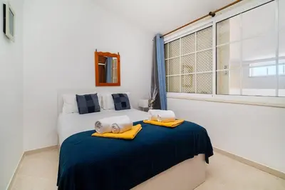 a bedroom with a bed and a desk with towels on it at Ponta Grande Resort - Villa Solmar in Albufeira