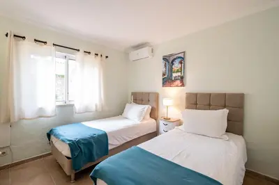 a bedroom with two beds and a window at Villa Louanna in Vilamoura
