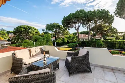 a patio with wicker chairs and a table at Villa Louanna in Vilamoura