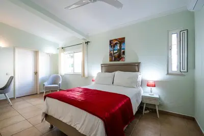a bedroom with a large bed with a red blanket at Villa Louanna in Vilamoura