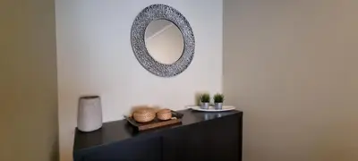 a mirror on a wall above a black dresser at Pórtico de Malpique in Albufeira