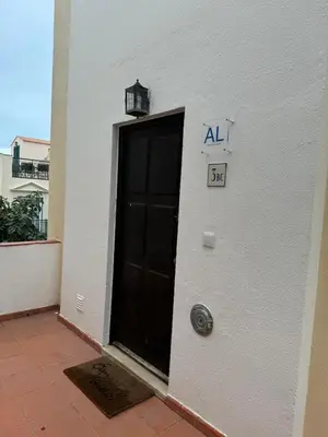 a building with a black door with a sign on it at Casa Estrelinha Vilamoura in Quarteira