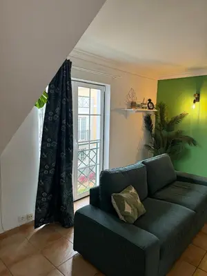 a living room with a couch and a window at Casa Estrelinha Vilamoura in Quarteira