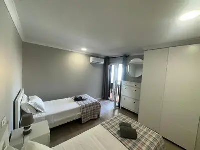 a small bedroom with a bed and a window at Cliff Enchantment - Pool and Sea View in Albufeira in Albufeira
