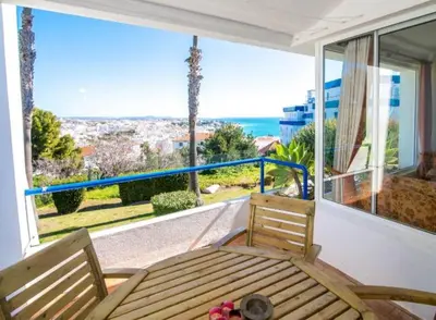a balcony with a wooden bench and a large window at Windmill Hill Luxury Apartment in Albufeira