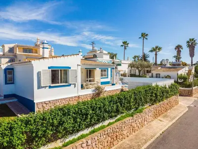 a white house with a stone wall at Villa Gabriella - Charming villa in great location close to everything you need in Guia