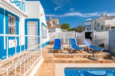 a balcony with blue chairs and a swimming pool at Villa Gabriella - Charming villa in great location close to everything you need in Guia