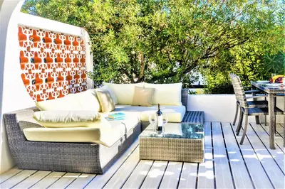 a patio with a couch and a table on a deck at Vale do Lobo Apartment in Vale do Lobo