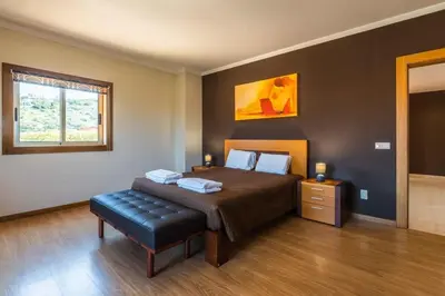 a bedroom with a bed and a bench in it at Villa Hugo - bright modern walk to restaurants in Albufeira