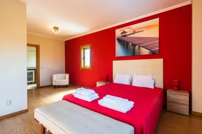 a red bedroom with a bed with a red wall at Villa Hugo - bright modern walk to restaurants in Albufeira