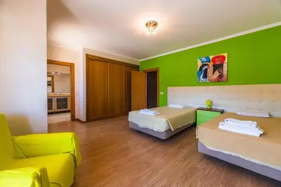 a room with two beds and a green wall at Villa Hugo - bright modern walk to restaurants in Albufeira