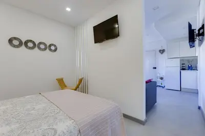 a bedroom with a bed and a tv on a wall at BELLAVISTA STUDIO - Modern and Renovated near Fishermen's Beach in Albufeira