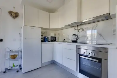 a white kitchen with a stove and a refrigerator at BELLAVISTA STUDIO - Modern and Renovated near Fishermen's Beach in Albufeira