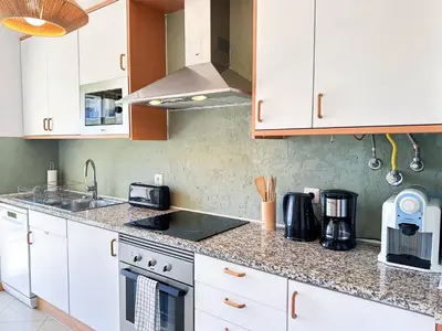 a kitchen with white cabinets and a counter top at Azure Heaven by BeCherish in Páteo