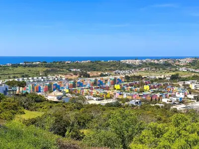 a city with colorful buildings and the ocean at Azure Heaven by BeCherish in Páteo