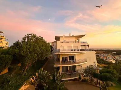 a white building with a bird flying above it at Azure Heaven by BeCherish in Páteo