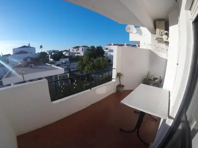a balcony with a table and a view of a city at Apartamento A11 - 800m da praia in Albufeira