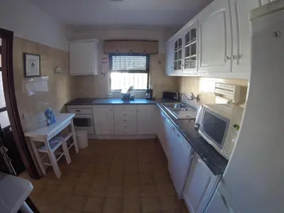 a kitchen with white cabinets and a sink and a microwave at Apartamento A11 - 800m da praia in Albufeira