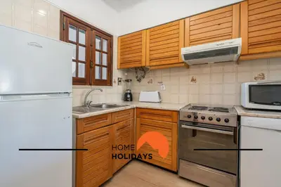 a kitchen with wooden cabinets and a white refrigerator at #279 T2 Para Relaxar em Albufeira by Home Holidays in Albufeira
