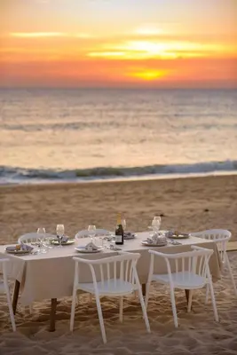 a dinner table on the beach at sunset at Beach front right on the Sand Luxury semi-detached 3 bed Villa in Faro