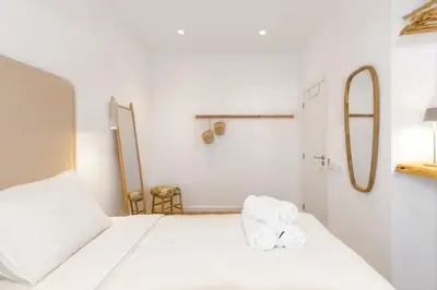 a white bedroom with two towels on a bed at Beach front right on the Sand Luxury semi-detached 3 bed Villa in Faro