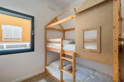 a bunk bed room with two bunk beds and a window at Beach front right on the Sand Luxury semi-detached 3 bed Villa in Faro